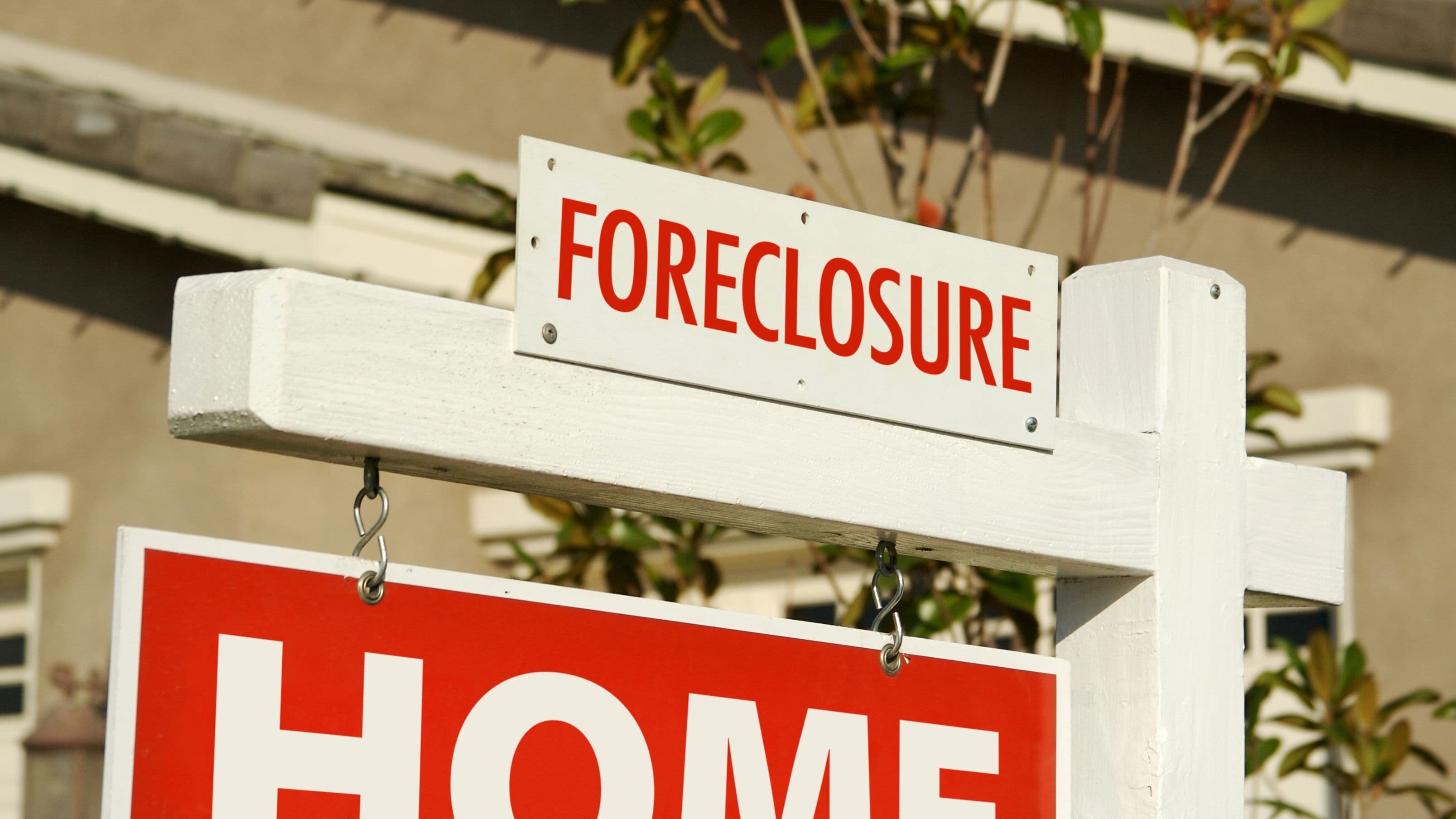 Close-up of Foreclosure sign in front of a house.